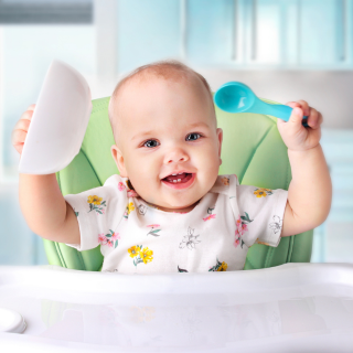 Foto de bebê em volta de diversos alimentos iniciando a introdução alimentar